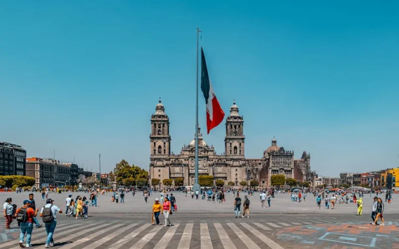 A bustling scene of Zócalo Square, Mexico City with the majestic Metropolitan Cathedral and vibrant activity.