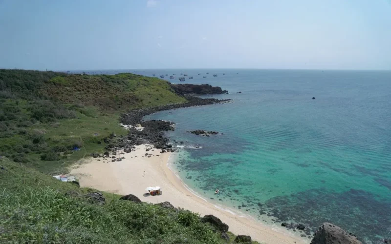 Aerial view of a serene beach and turquoise ocean in Phan Thiết, Vietnam.