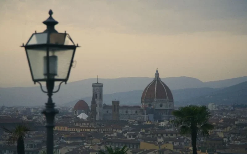 A view of Florence with the iconic Duomo and distant hills under a twilight sky.