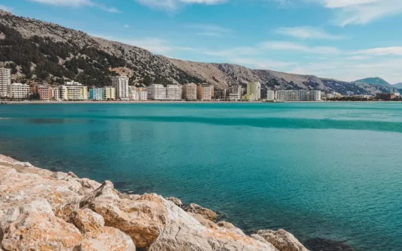 Scenic view of Vlora's coast with crystal blue waters and mountain backdrop, perfect for travel inspiration.
