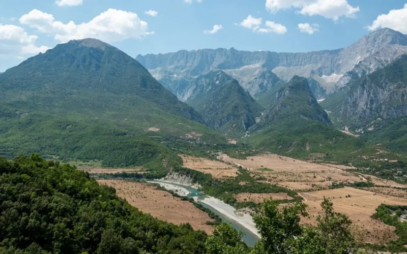 Aerial view of Përmet valley with lush greenery and majestic mountains in Albania.
