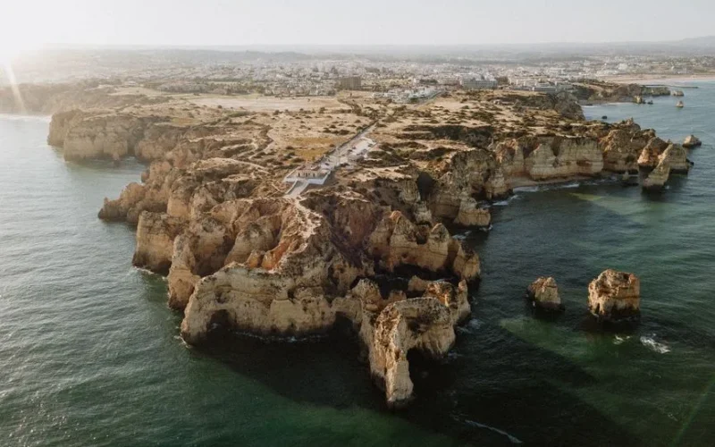 Aerial view of the stunning cliffs and coastline of Algarve, Portugal, with crystal clear sea water.