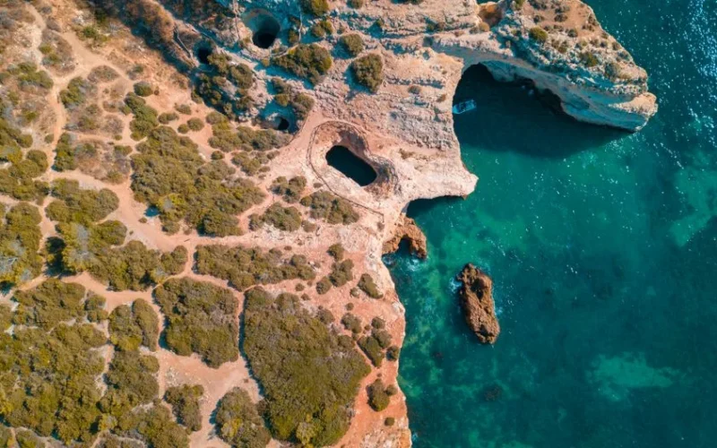 Stunning aerial view of the scenic Algarve coastline with natural caves and turquoise water.
