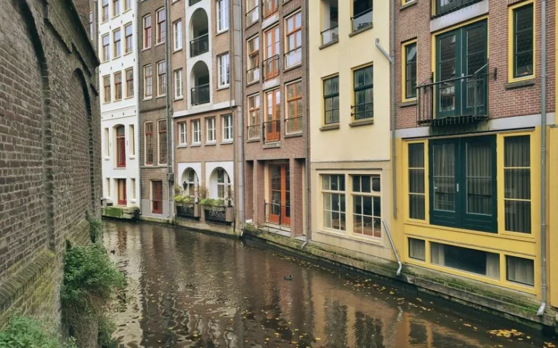 Picturesque Amsterdam canal lined with vibrant townhouses and reflections on the water.