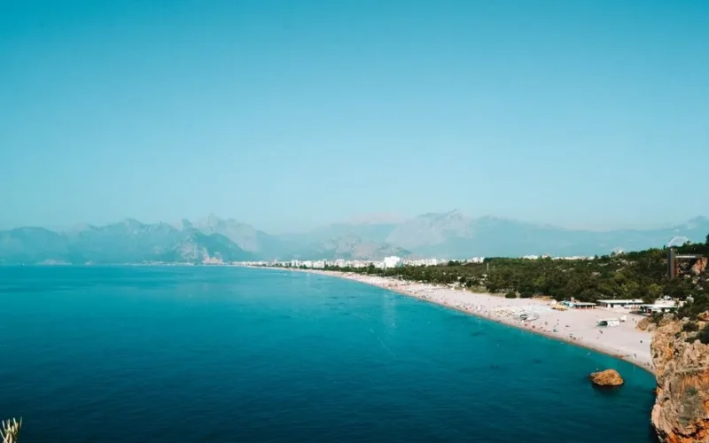 A breathtaking aerial view of Konyaalti Beach with turquoise waters and distant mountains in Turkey.