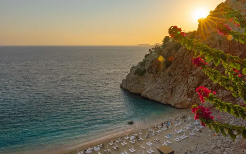 Captivating sunset view of Kaputas Beach in Antalya, featuring vibrant flowers and tranquil waters.