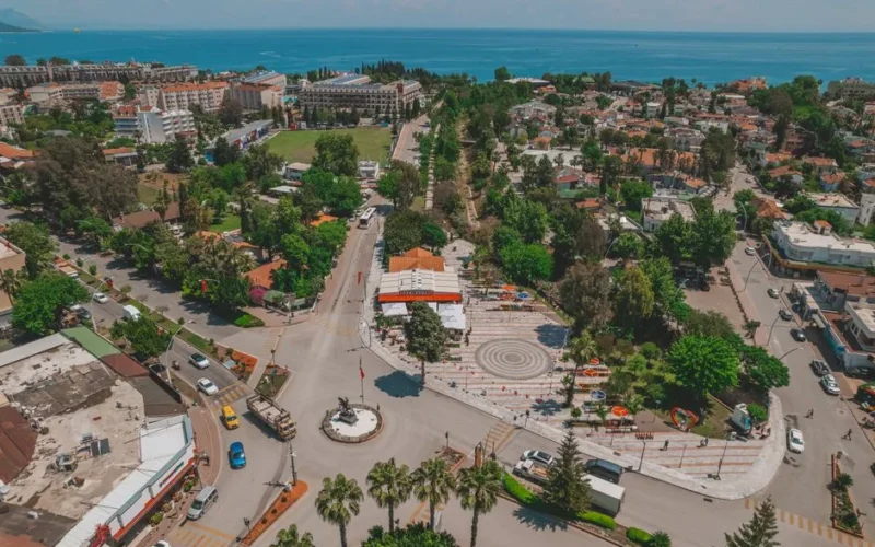 A vibrant aerial view showcasing Kemer cityscape with roads, greenery, and sea in Antalya, Türkiye.