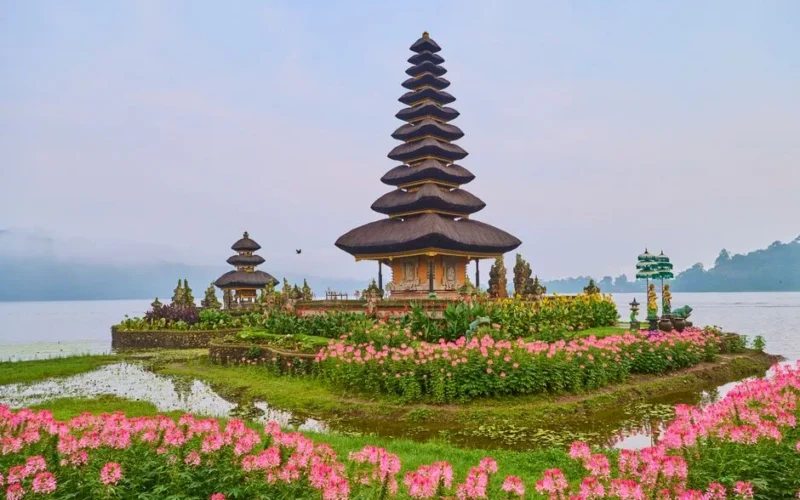 Beautiful Ulun Danu Beratan Temple in Bali, surrounded by colorful flowers and a serene lake.