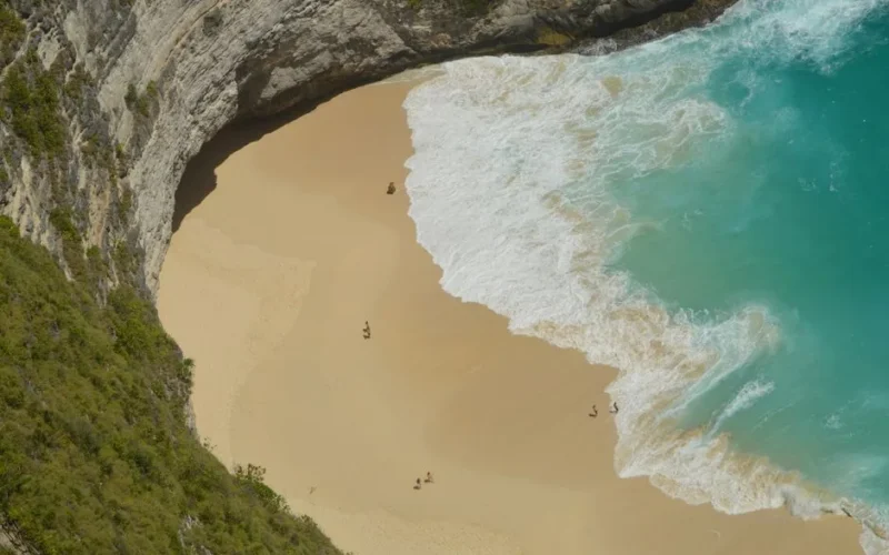 A breathtaking aerial view of a secluded beach in Bali, Indonesia with turquoise waters.