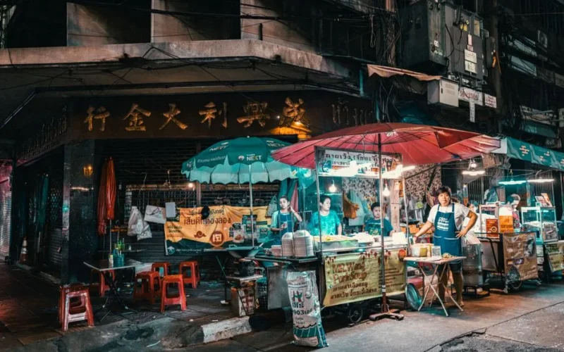 Vibrant night market scene in Bangkok showcasing street food vendors and bustling activity.