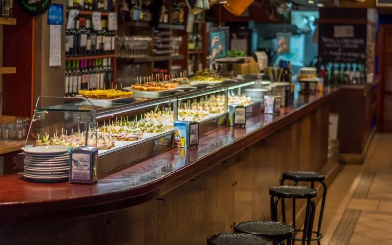 Explore a vibrant tapas bar in Barcelona with a wide selection of pinchos on display.