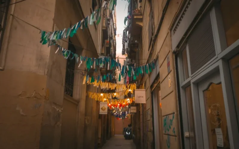 A vibrant alleyway with decorative bunting and warm lighting in a historic urban setting.
