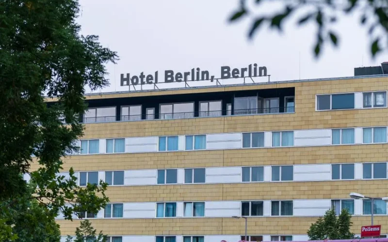 Explore the modern architecture of Hotel Berlin amidst lush greenery in the cityscape.