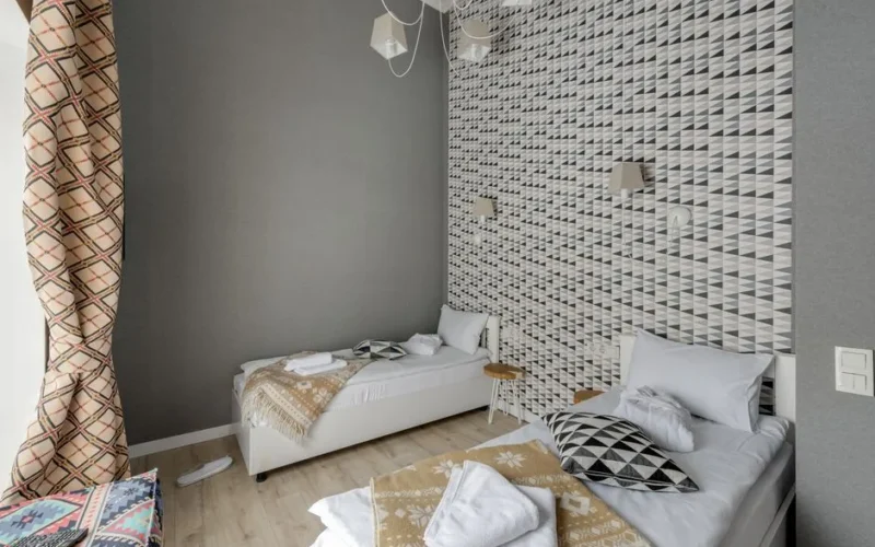Stylish hotel room featuring modern geometric wallpaper and elegant interior design.