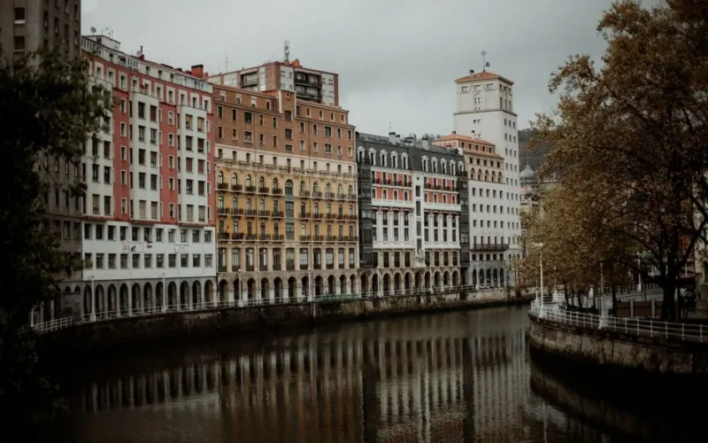 Charming riverside buildings in Bilbao capturing classic architecture with autumn reflections.
