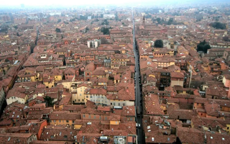 Aerial shot of Bologna, Italy showcasing its historic red rooftops and medieval architecture.