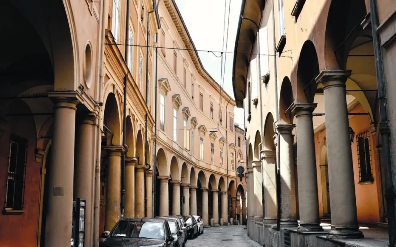 Explore the historic arcades of Bologna, Italy, lined with elegant columns.