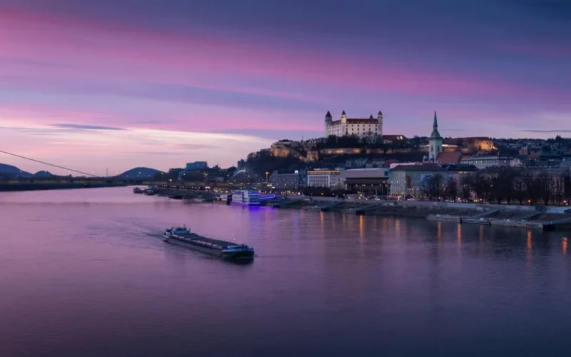 A picturesque view of Bratislava Castle and Danube River at sunset, showcasing Slovakia's scenic cityscape.