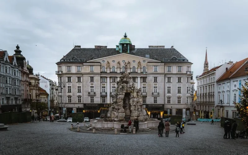 Explore the historic town square in Brno, Czechia, featuring classic architecture and a central fountain.