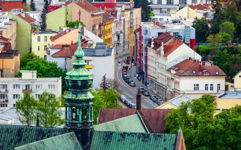 Aerial view of the colorful cityscape of Brno, highlighting its green tower and gothic architecture.