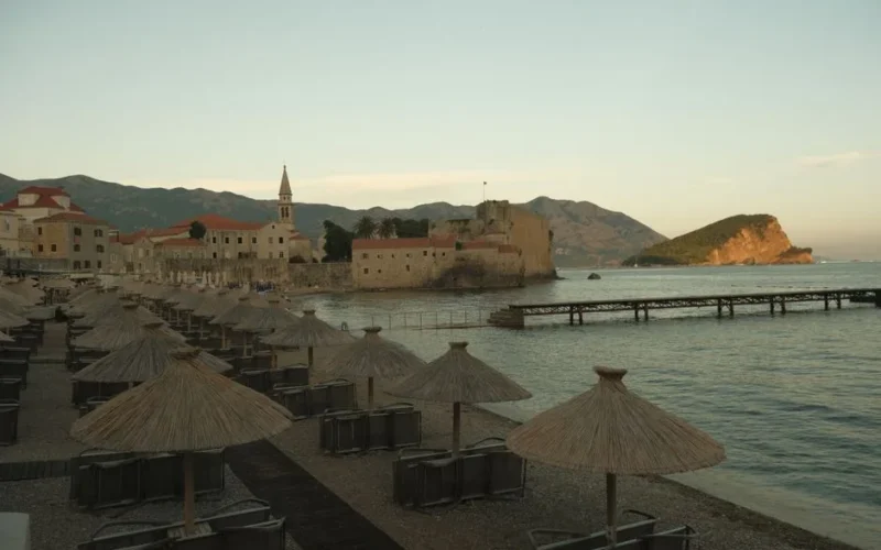 Scenic view of Budva Old Town at sunset with beach umbrellas in Montenegro.