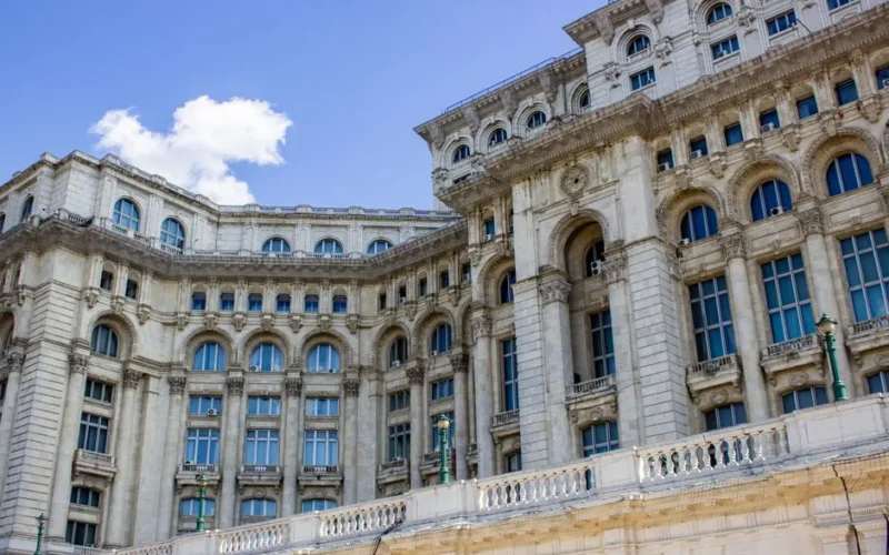 Ornate facade of Palace of the Parliament in Bucharest under clear blue sky.