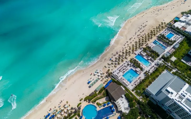 Stunning top view of a Cancun beach resort with turquoise water and sandy shore.
