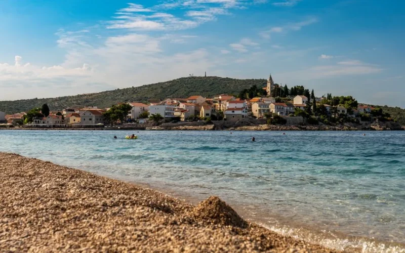 A stunning view of Primošten beach with sparkling waters and charming architecture.