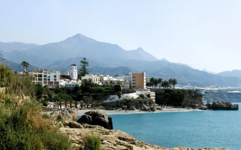Picturesque coastal town of Nerja with stunning mountains and clear blue sea.