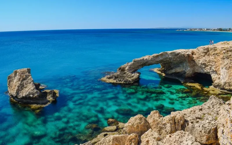 Idyllic coastal view of Cyprus arch and turquoise sea, perfect for summer travel inspiration.