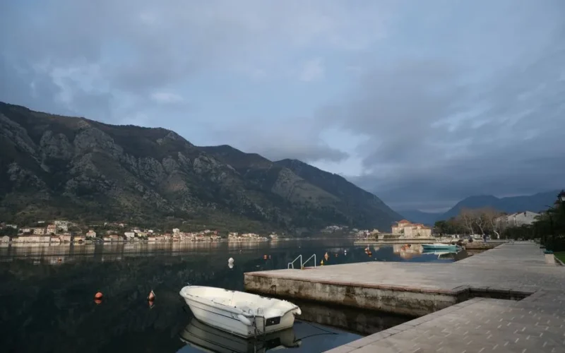 Peaceful morning view of Kotor Bay in Montenegro, showcasing calm waters and mountainous backdrop.