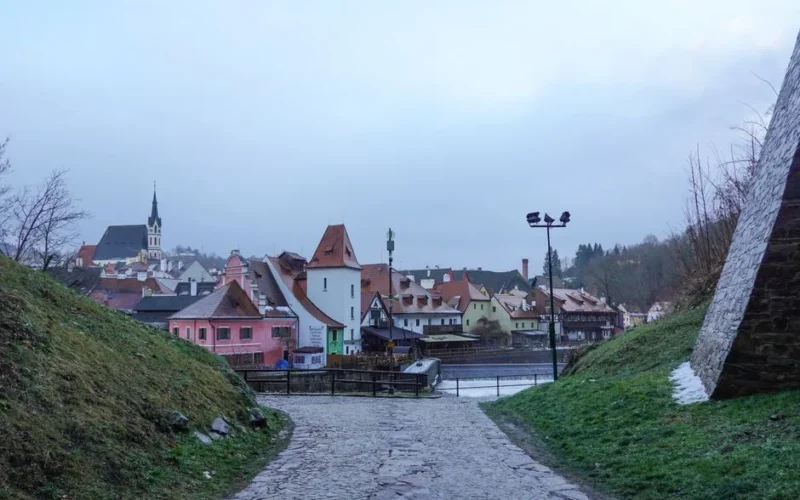 Panoramic view of Český Krumlov with cobbled paths and historic architecture under an overcast sky.