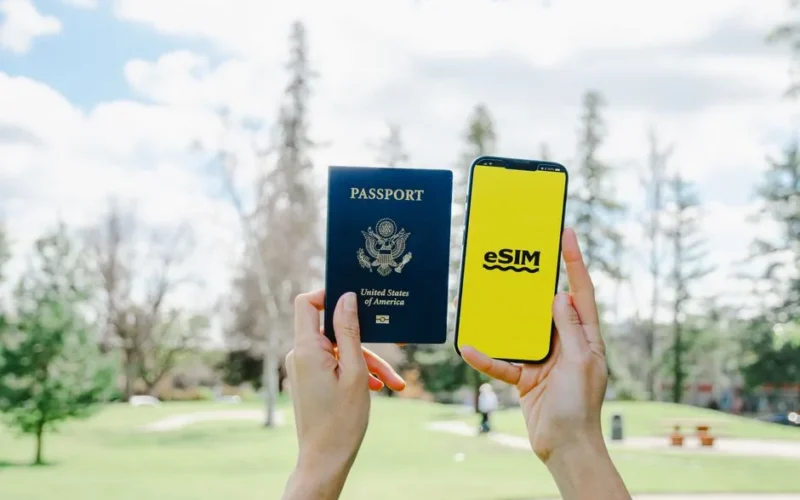 Holding Passport and Smartphone with eSim Application