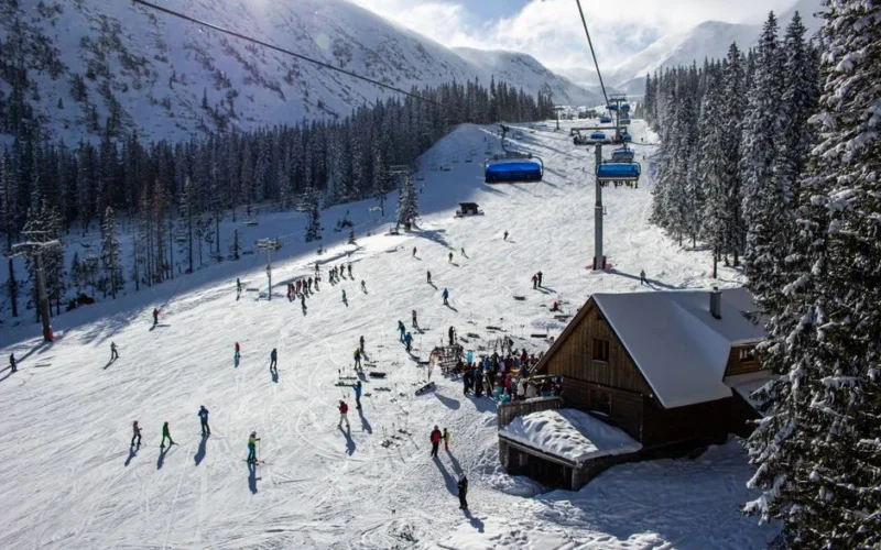 A vibrant ski resort scene in Zuberec, Slovakia, showcasing skiers and snowy slopes.