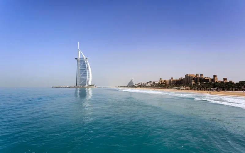 Iconic Burj Al Arab overlooking the pristine Dubai beach, perfect for travel and leisure.