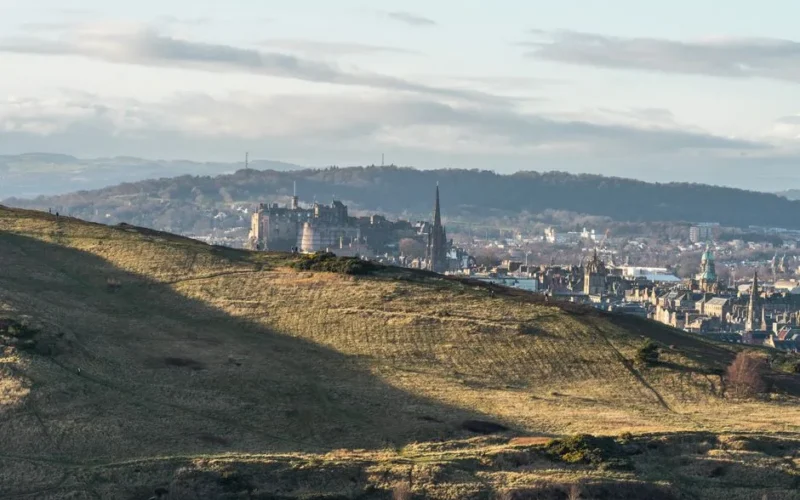 Beautiful panoramic view of Edinburgh's historic skyline with Edinburgh Castle and Arthur's Seat in the foreground.