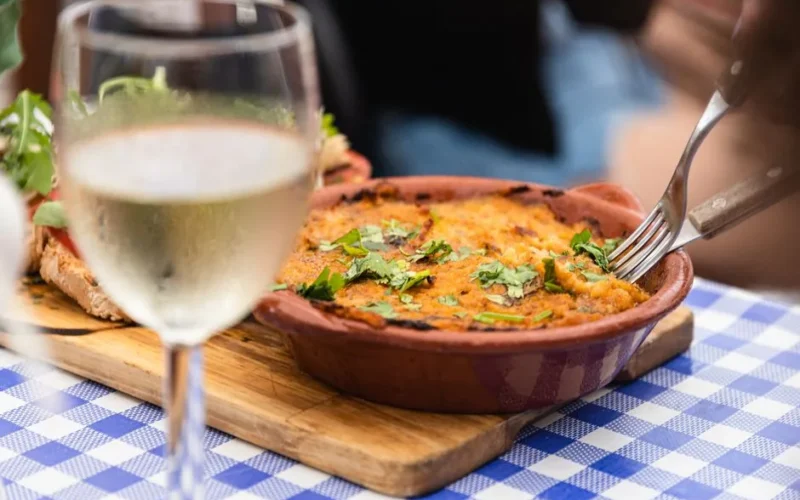 A delicious Portuguese dish served with white wine in a restaurant setting in Faro, Portugal.
