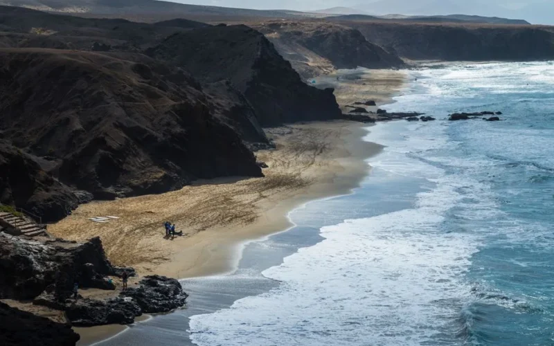 Stunning aerial view of Playa del Viejo Reyes with cliffs and crashing waves in Canary Islands.
