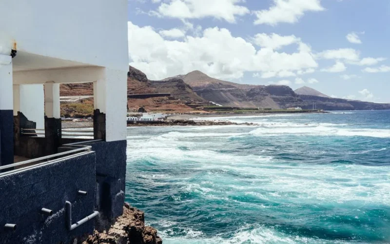 Breathtaking coastal view of Gran Canaria with waves hitting the shore under a sunny sky.