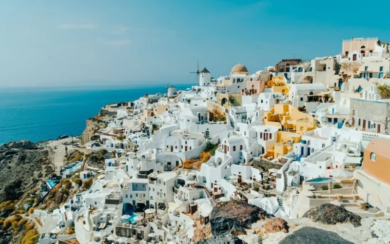 Captivating aerial view of Fira's iconic white architecture and the Aegean Sea in summer.