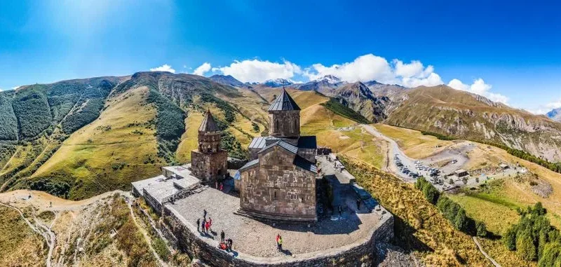 A breathtaking aerial shot capturing Gergeti Trinity Church amidst Georgia's scenic mountains.