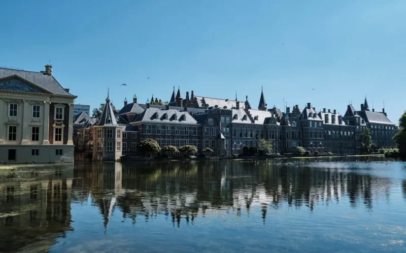 Scenic view of historic buildings reflecting on a serene canal in a European city.