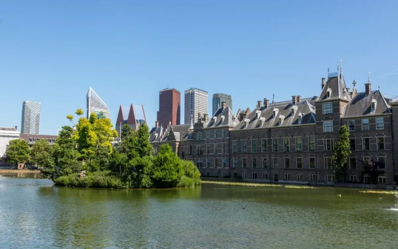 Beautiful view of Binnenhof and modern skyline of The Hague reflecting in the Hofvijver on a sunny day.