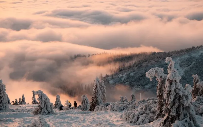Explore the serene snow-covered peaks and misty clouds of Liberecký kraj in winter's embrace.