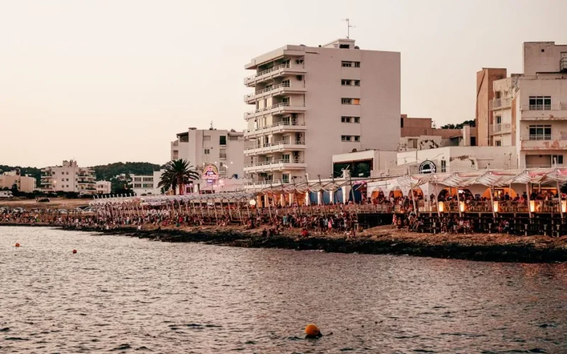 Lively Ibiza waterfront scene showcasing vibrant coastal nightlife at sunset.