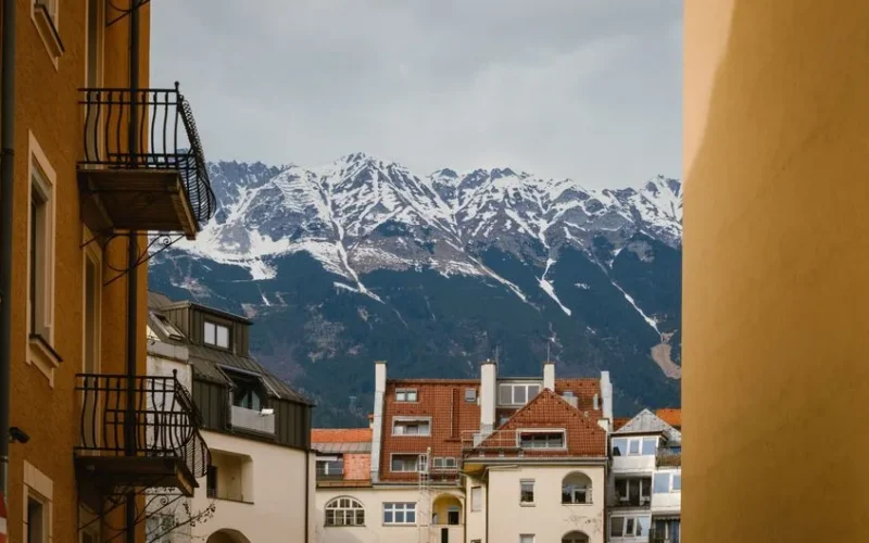 Picturesque view of Innsbruck's architecture framed by the stunning snow-capped Alps.
