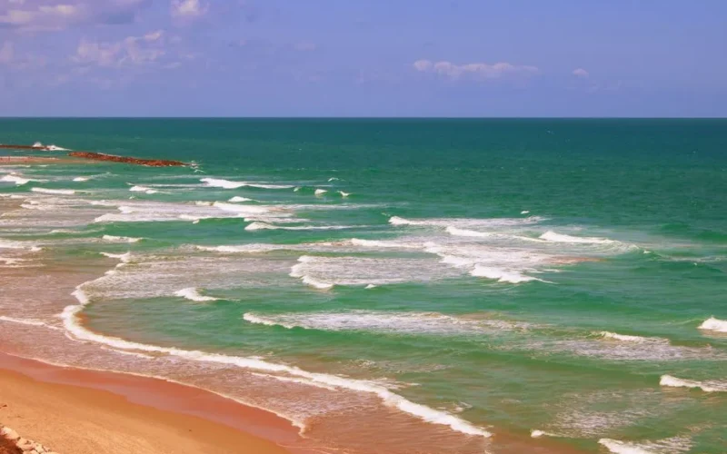 Beautiful coastal view of the Mediterranean Sea in Netanya, Israel, with turquoise waves and sandy shores.