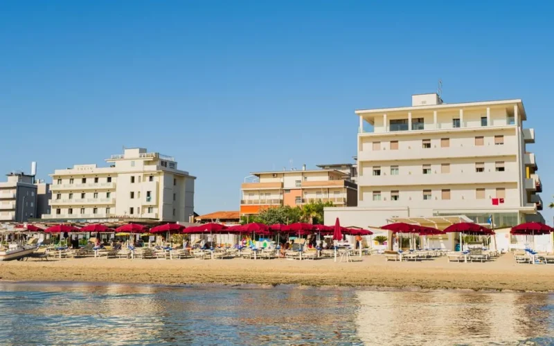 Stunning Lido di Savio beachfront view with hotels and umbrellas under a clear summer sky.