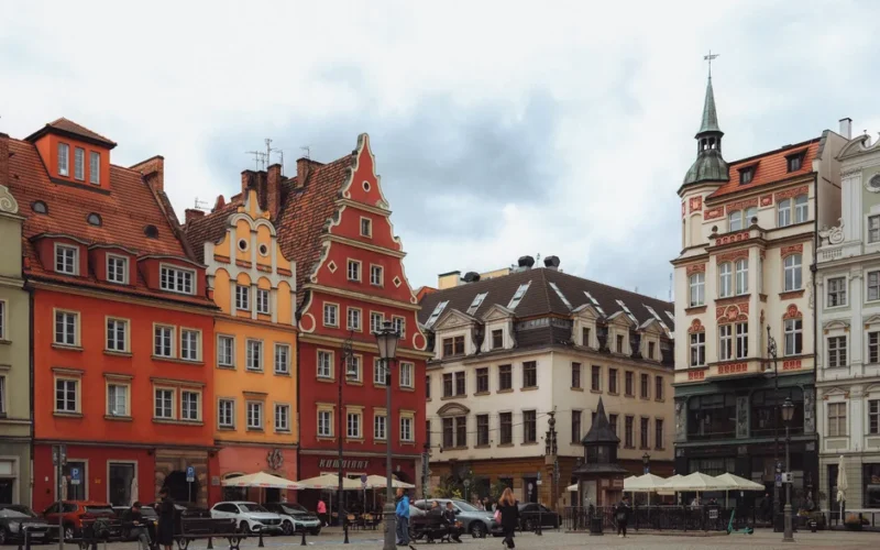 Colorful gabled buildings in Breslau's city square under cloudy skies.