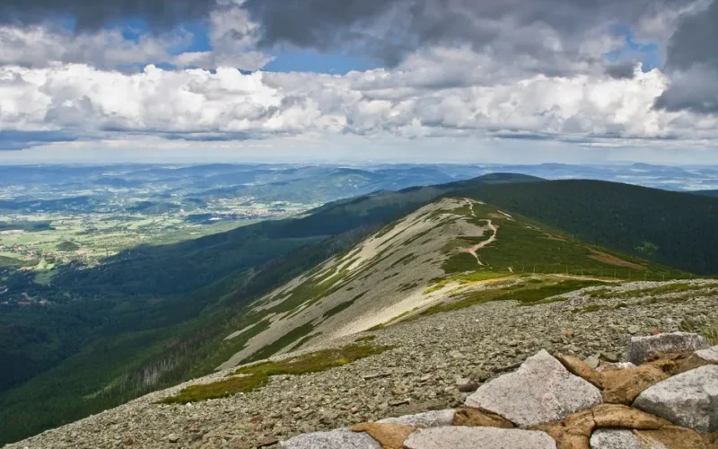 Stunning panoramic view of Karkonosze Mountains under cloudy sky.